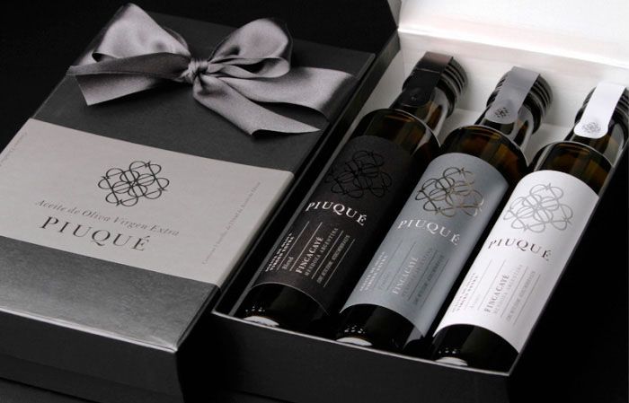 set de regalo con tres botellas de vidrio oscuro muy elegantes y diferentes de aceite de oliva premium, con etiquetas con estamping metálico y precinto de garantía en tapón pilfer