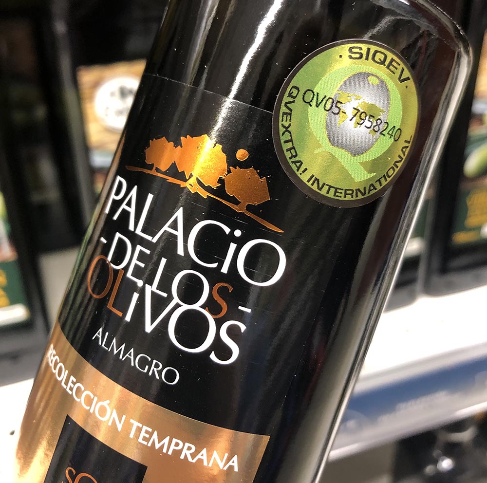 etiqueta sello siqev - qvextra sobre botella de aceite de oliva virgen extra