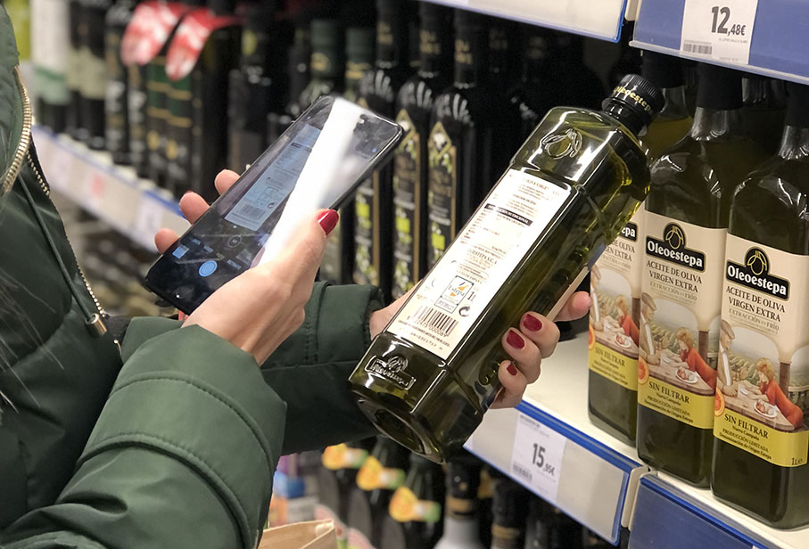 Mujer Escanea un QR en una etiqueta de aceite de oliva